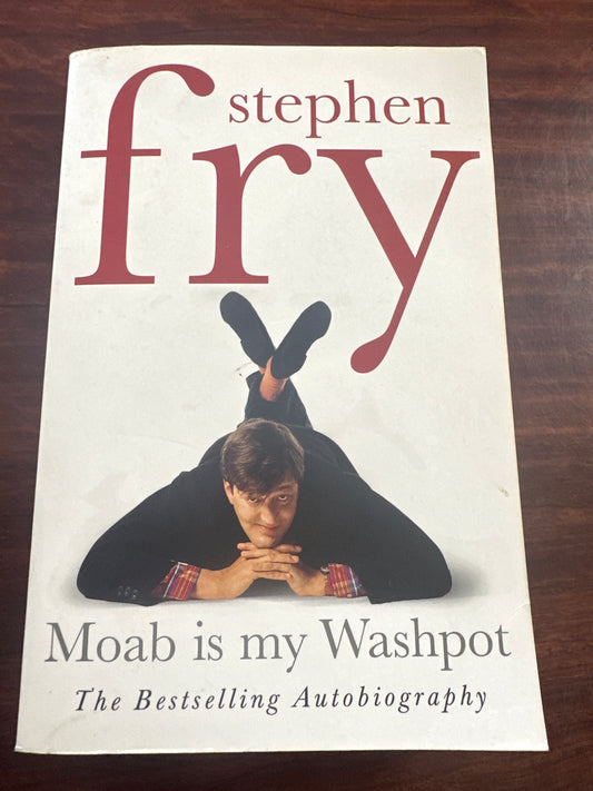 Book cover of 'Moab is my Washpot' by Stephen Fry on a wooden surface