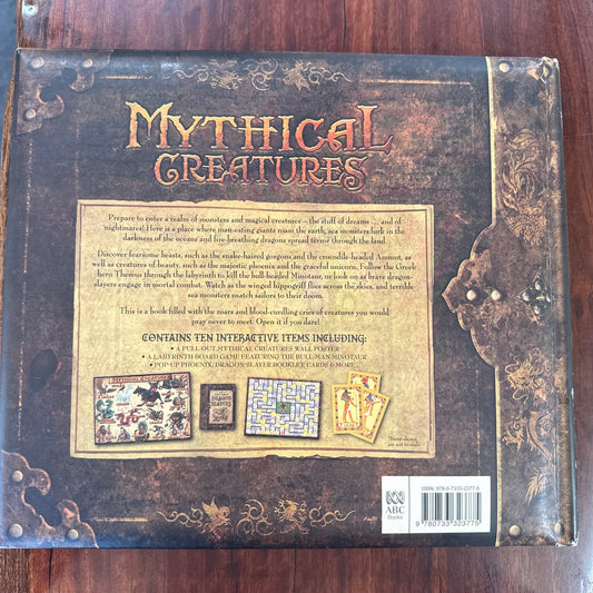 Decorative book titled 'Mythical Creatures' on a wooden surface