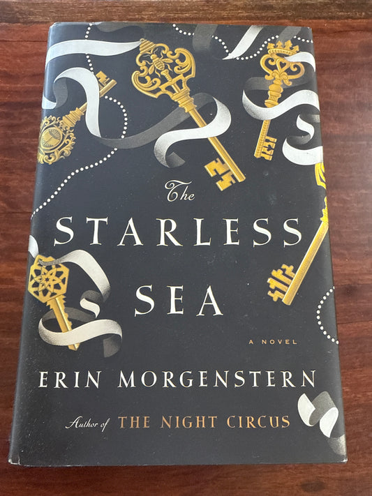 Book titled 'The Starless Sea' by Erin Morgenstern on a wooden surface