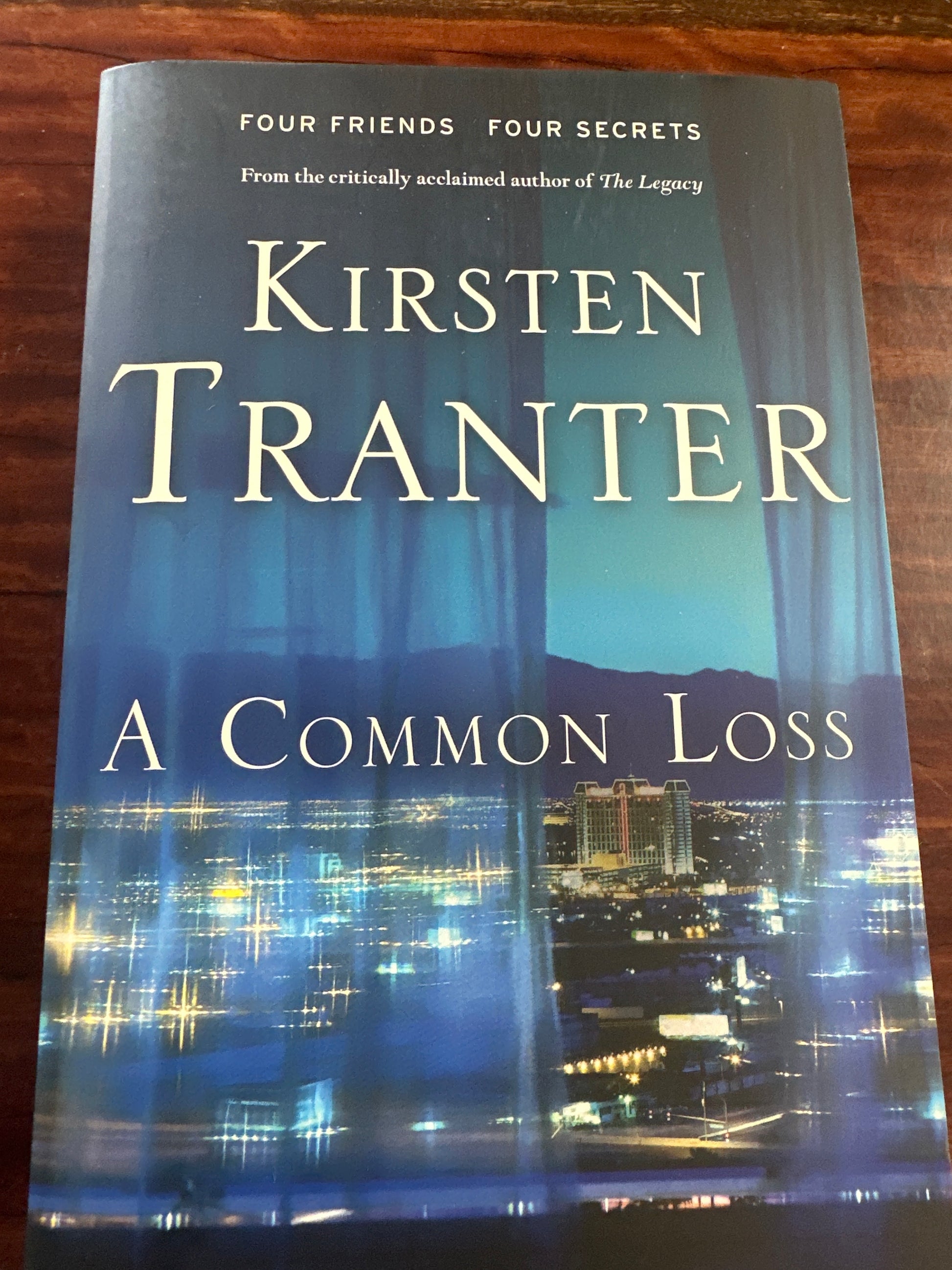 Book titled 'A Common Loss' by Kirsten Tranter on a wooden surface
