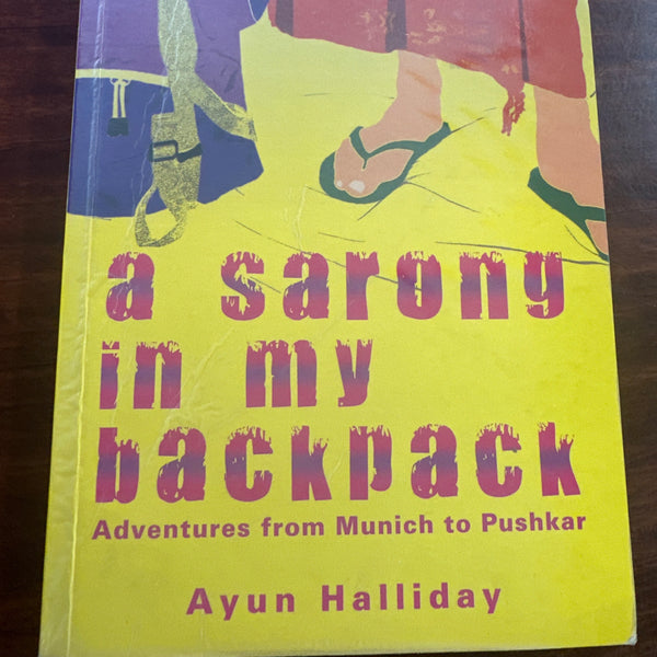 Book cover of 'A Sarong in My Backpack' by Ayun Halliday on a wooden surface