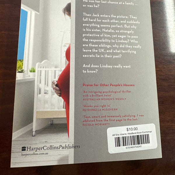 Back cover of Book titled 'All She Wants' by Kelli Hawkins on a wooden surface