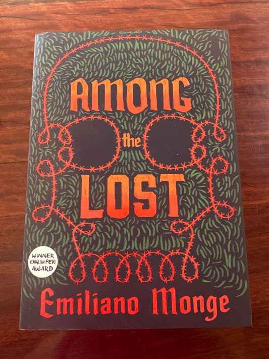 Book titled 'Among the Lost' by Emiliano Monge on a wooden surface