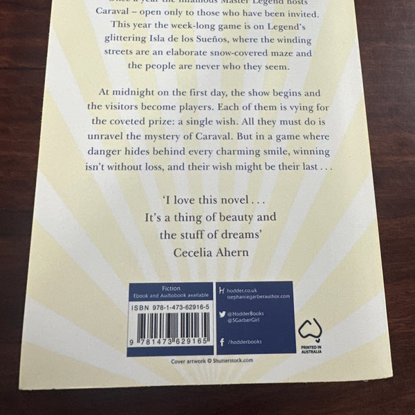 Back Book cover of 'Caraval' by Stephanie Garber on a wooden surface