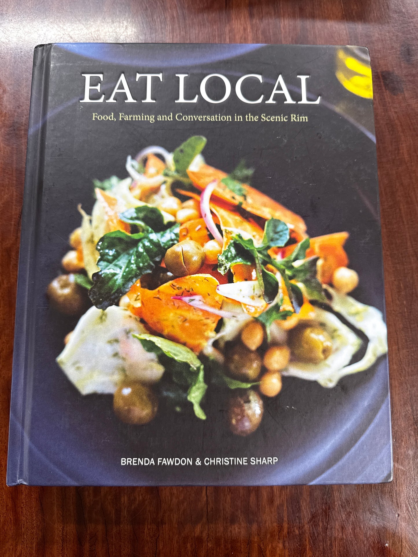 Book titled 'Eat Local' with a cover featuring food on a wooden surface