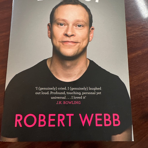 Book titled 'How Not to Be a Boy' by Robert Webb on a wooden surface