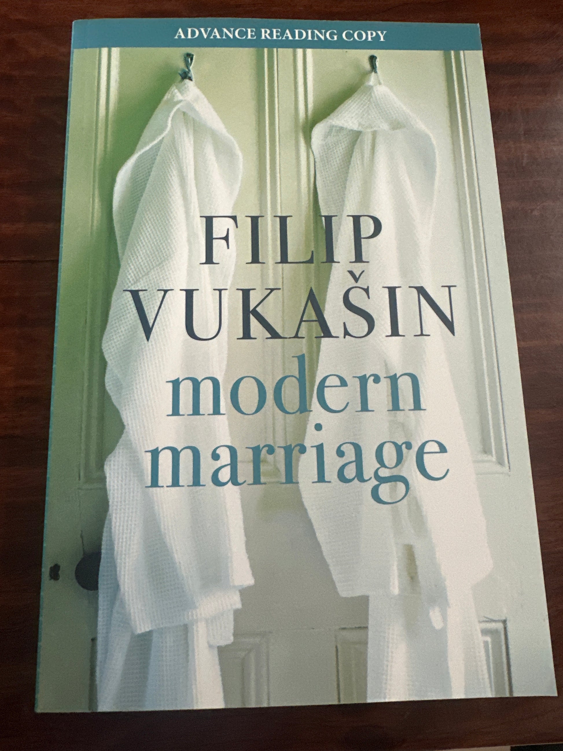 Book cover of 'Modern Marriage' by Filip Vukasin with a white dress on a wooden surface.