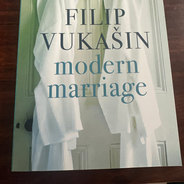 Book cover of 'Modern Marriage' by Filip Vukasin with a white dress on a wooden surface.