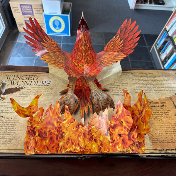 Pop-up book Mythical_Creatures with a phoenix design on a table