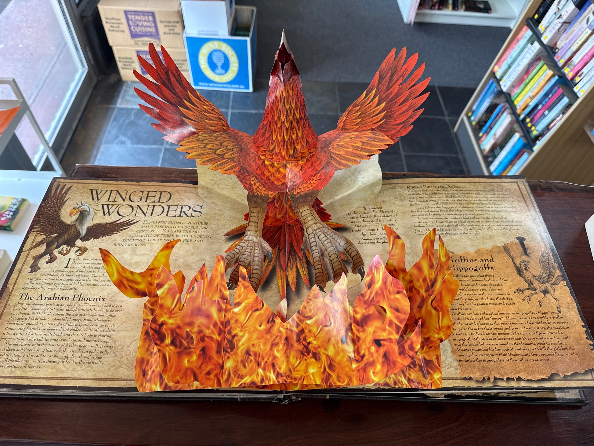Pop-up book Mythical_Creatures with a phoenix design on a table