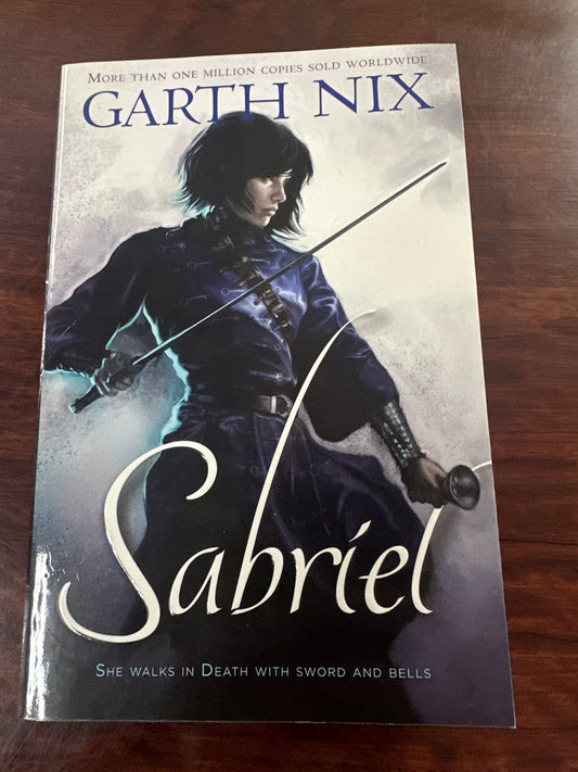 Book cover of 'Sabriel' by Garth Nix on a wooden surface