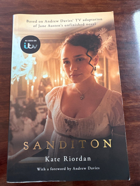 Book cover of 'Sanditon' by Kate Riordan on a wooden surface