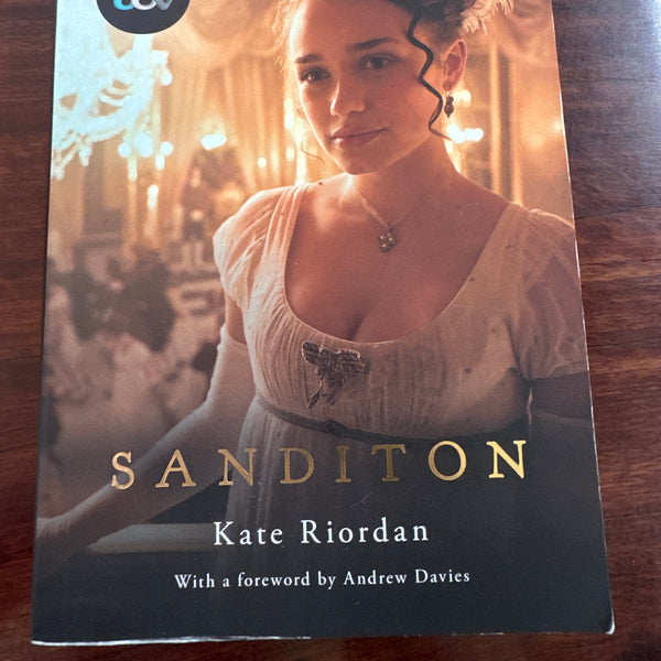 Book cover of 'Sanditon' by Kate Riordan on a wooden surface