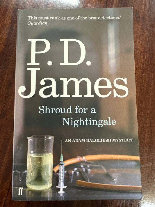 Book cover of 'Shroud for a Nightingale' by P.D. James on a wooden surface