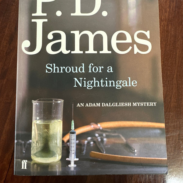 Book cover of 'Shroud for a Nightingale' by P.D. James on a wooden surface