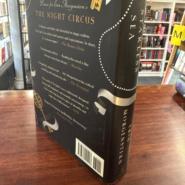 Book titled 'The Starless Sea' by Erin Morgenstern back cover on a wooden surface