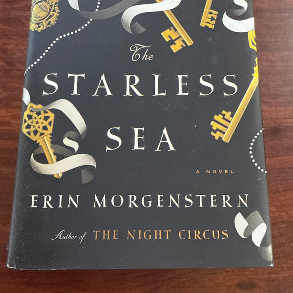 Book titled 'The Starless Sea' by Erin Morgenstern on a wooden surface
