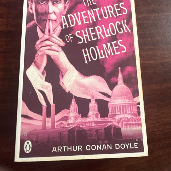 Book cover of 'The Adventures of Sherlock Holmes' by Arthur Conan Doyle on a wooden surface.