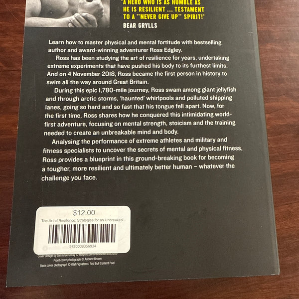 Back cover of 'The Art of Resilience' by Ross Edgley on a wooden surface