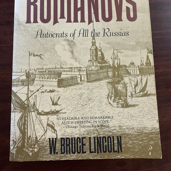Book cover of 'Romanovs: Autocrats of All the Russias' by W. Bruce Lincoln on a wooden surface.