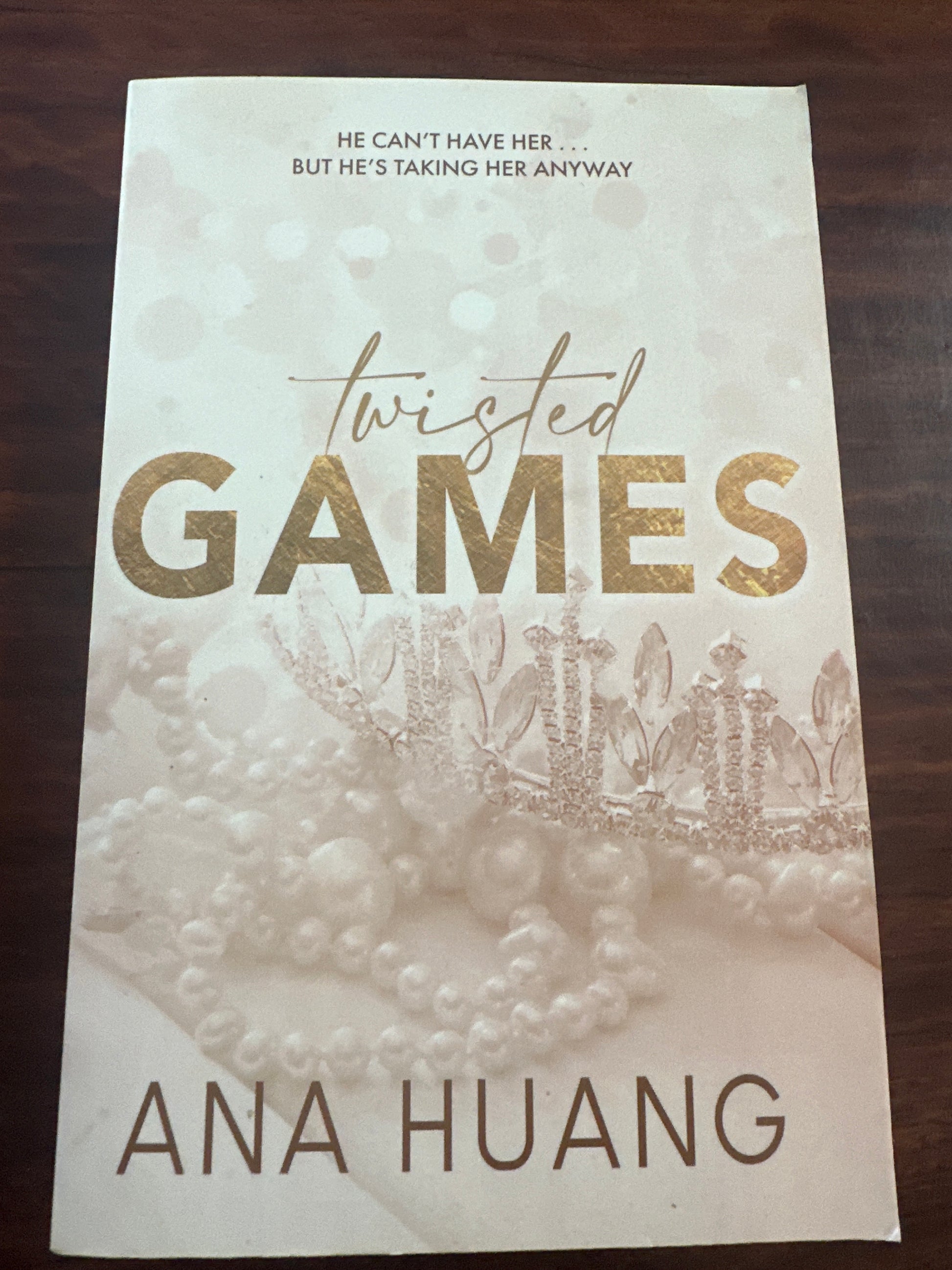 Book cover of 'Twisted Games' by Ana Huang on a wooden surface