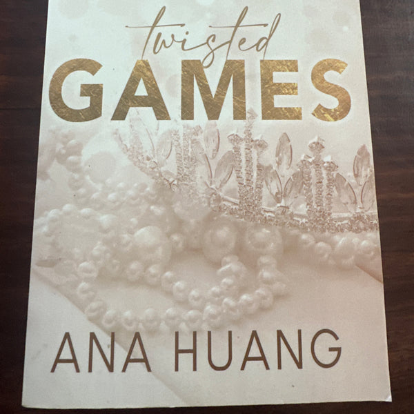 Book cover of 'Twisted Games' by Ana Huang on a wooden surface