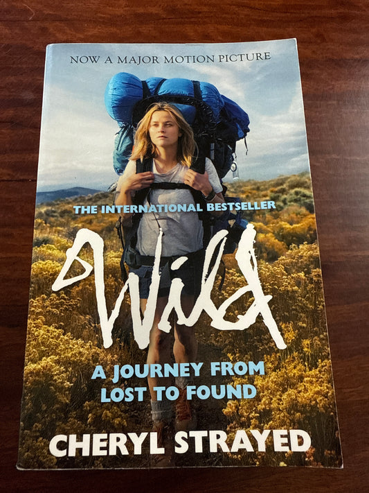 Book titled 'Wild' by Cheryl Strayed on a wooden surface