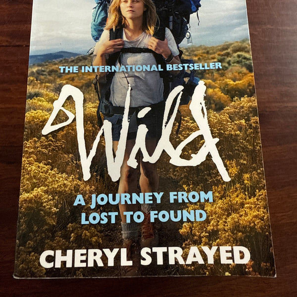 Book titled 'Wild' by Cheryl Strayed on a wooden surface