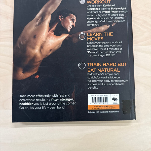 Book titled 'Train For It' by Bear Grylls on a wooden surface back cover